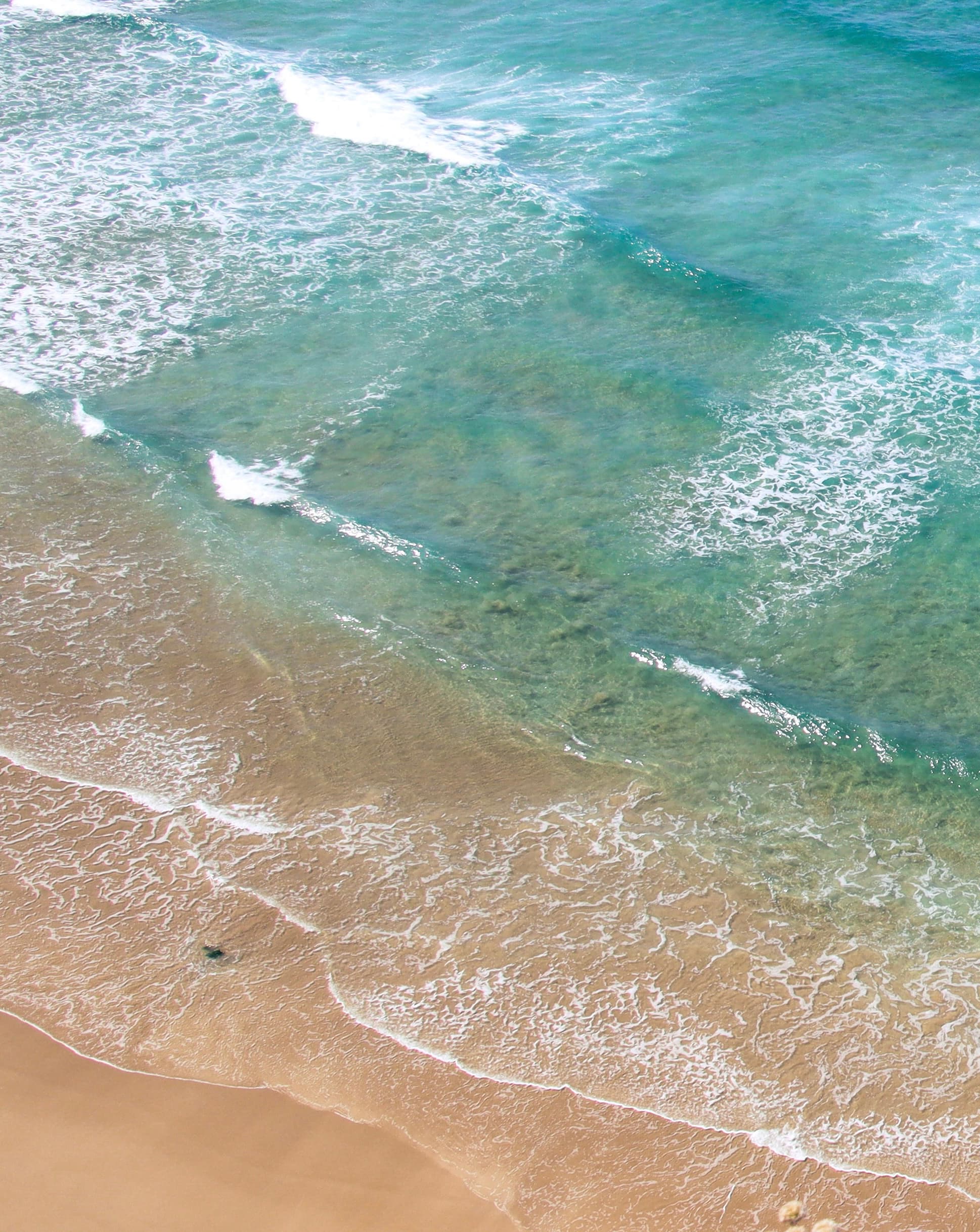 Aerial view of shoreline where sand meets sea