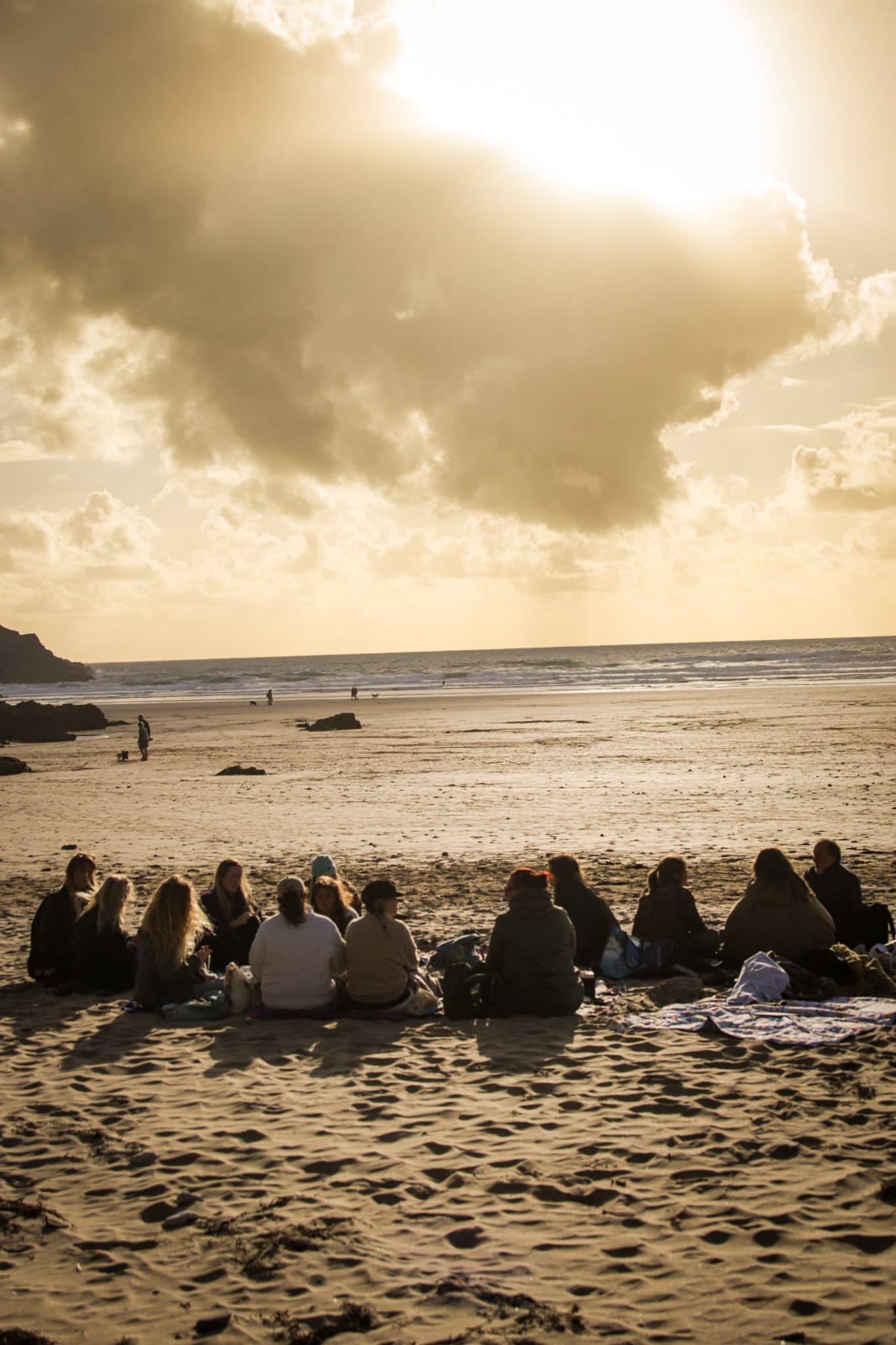 A group gathered on the beach at sunset