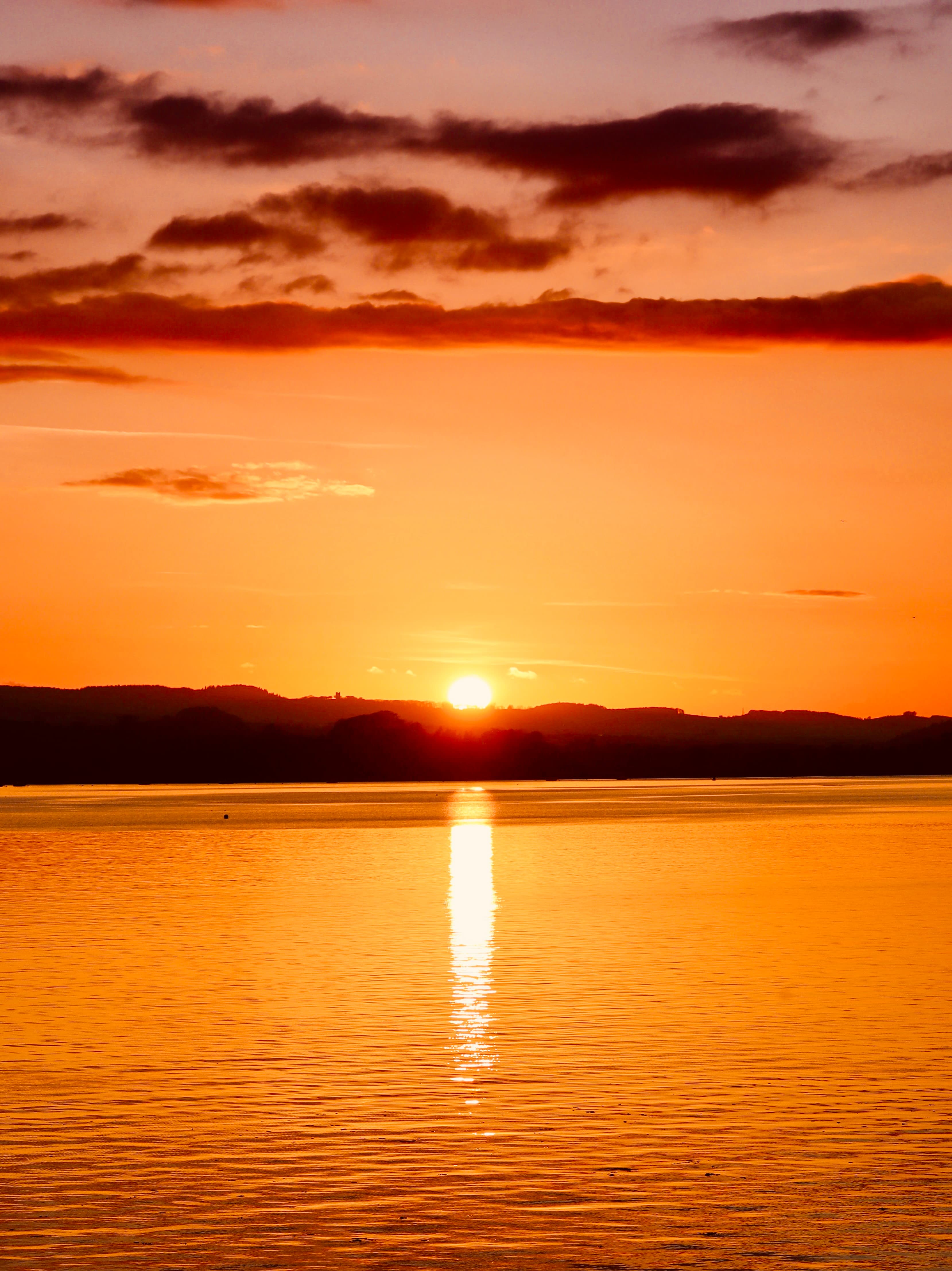 Sunset over rolling hills and the sea