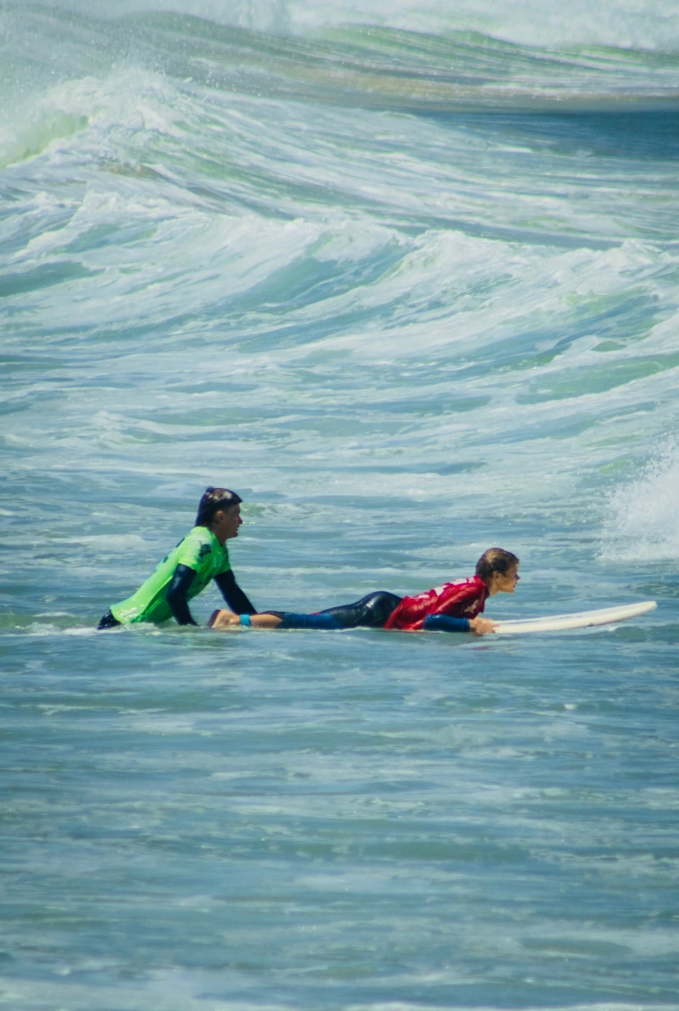 A surfer smiling mid-ride through whitewash