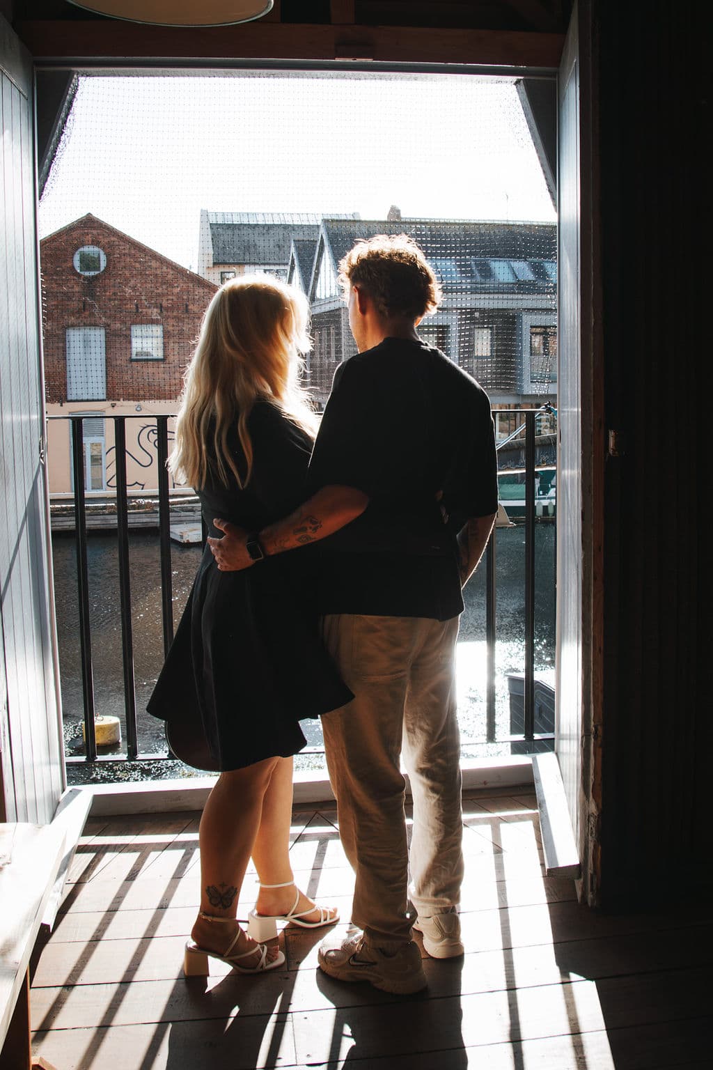 The couple, silhouetted, looking out over the water at dusk