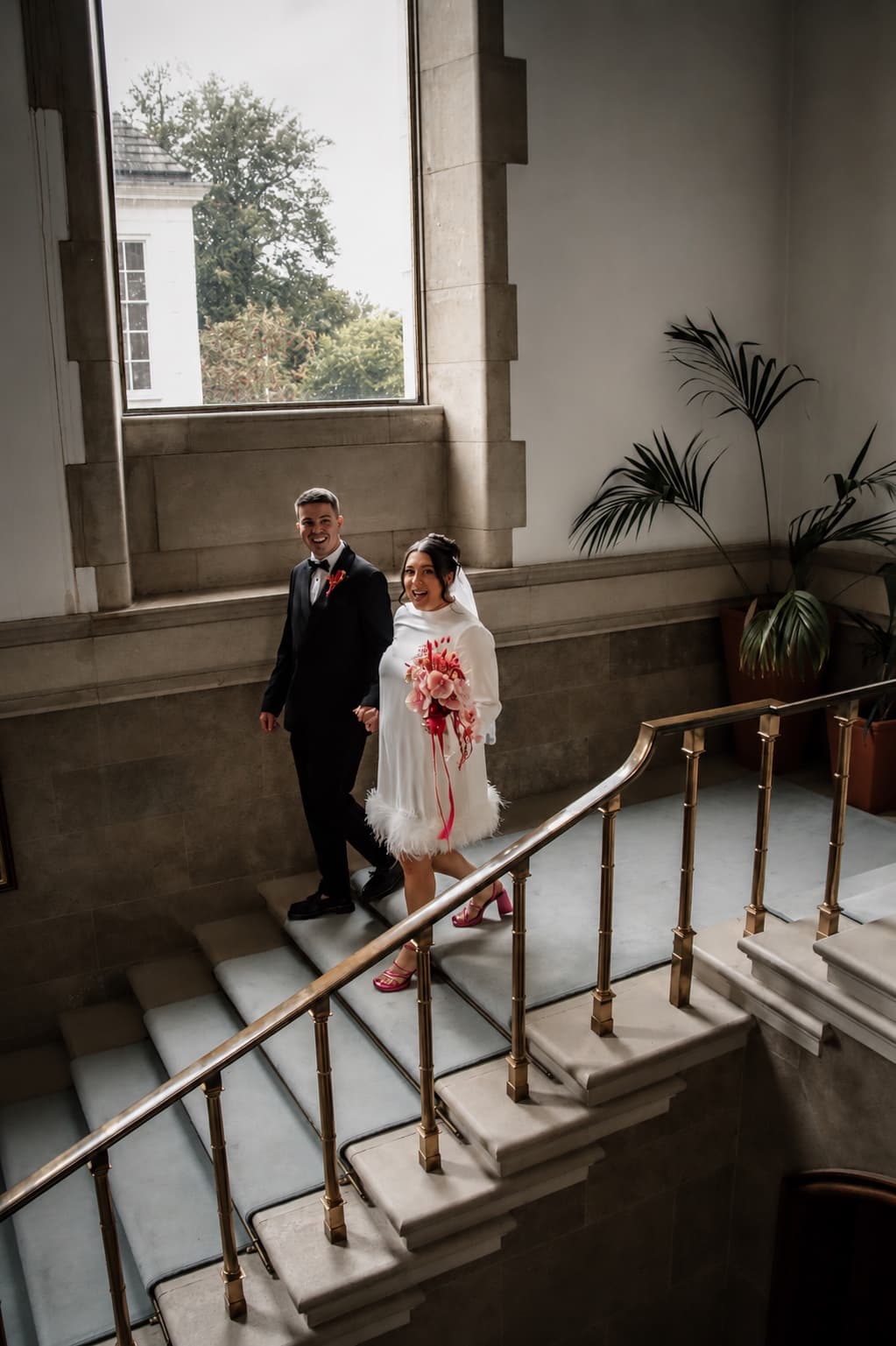 The couple on the grand staircase, just married, both laughing