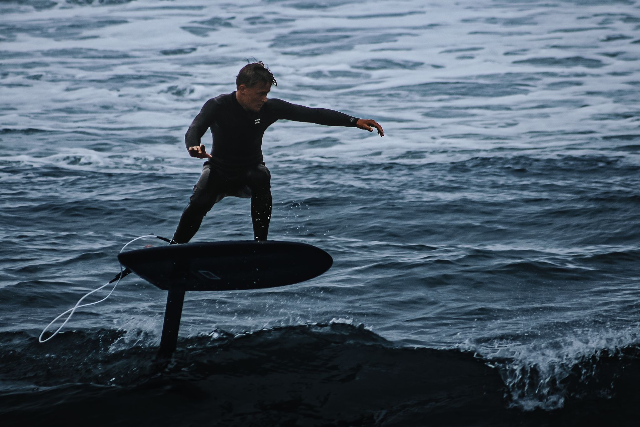 Foil surfer elevated above grey Atlantic water