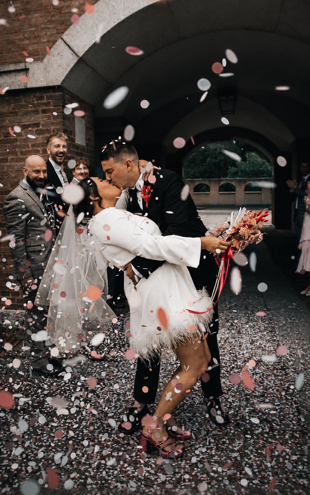 Couple dip kiss in colour confetti shower, peak joy