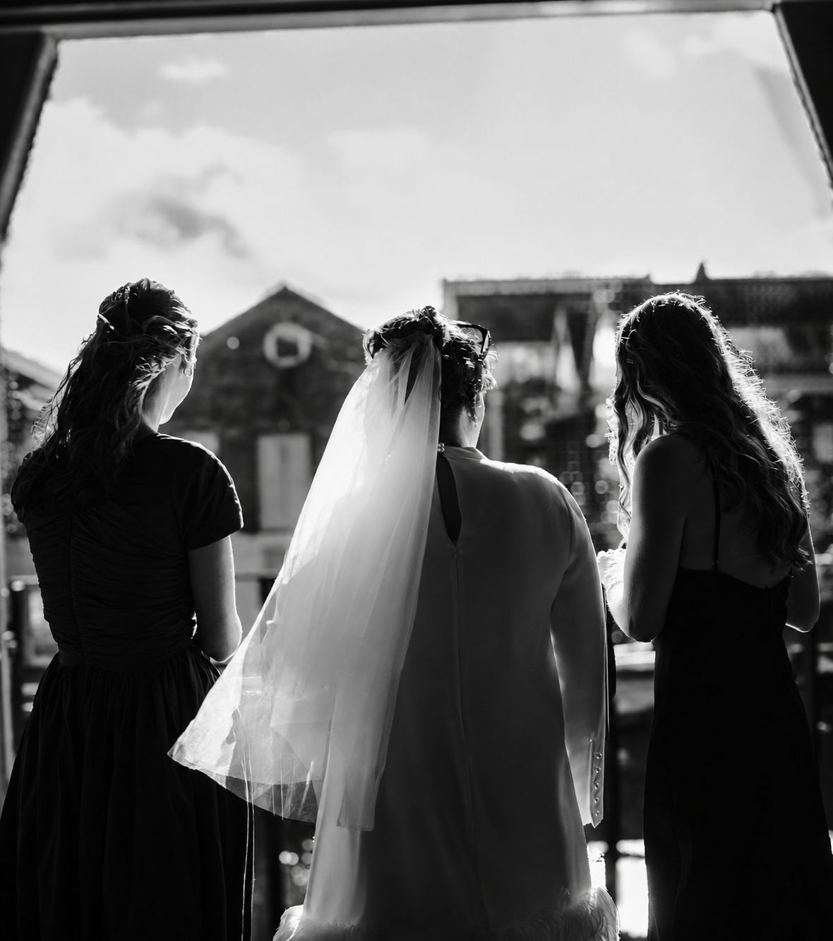 Three women silhouetted in doorway, backlit